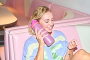A girl holding an Owala FreeSip to her ear