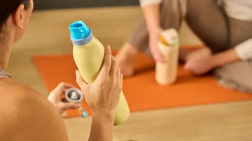 A person holding a yellow FreeSip Twist