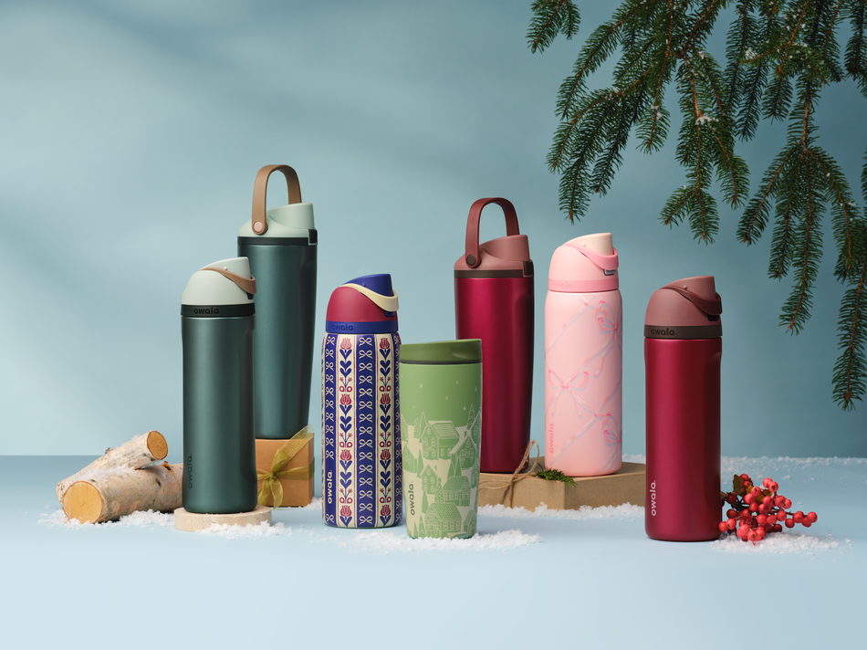 Holiday collection bottles beside a gingerbread house and tabletop decor