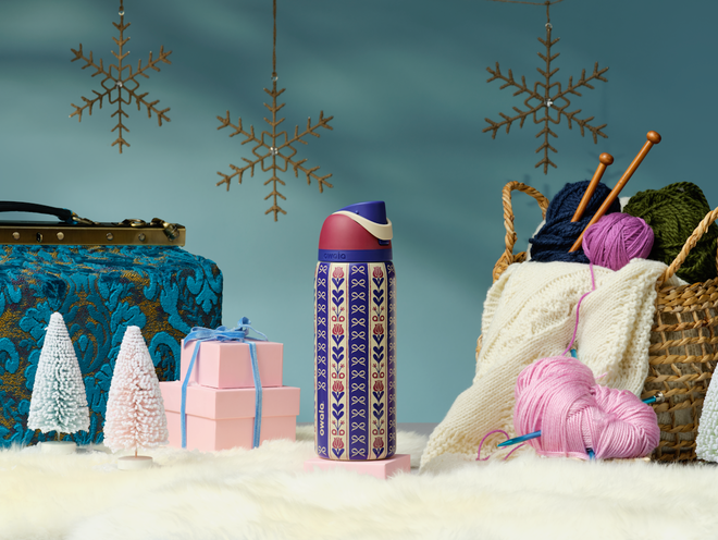 Holiday collection bottles in a pine and candle tabletop setup
