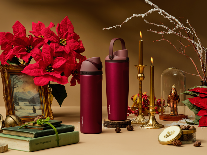 Holiday collection bottles with winter tabletop styling and evergreen accents